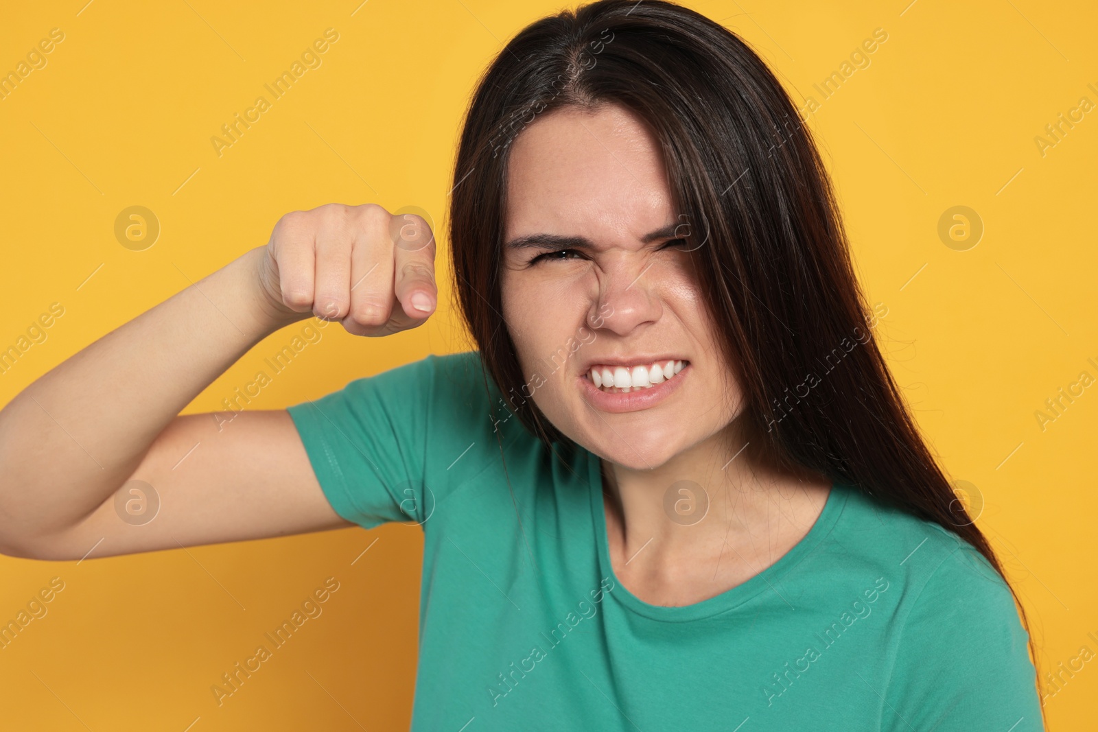 Photo of Aggressive young woman pointing on orange background