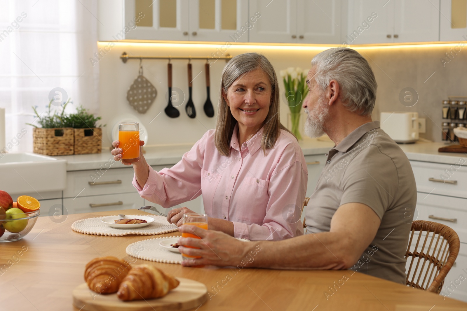 Photo of Happy senior couple having breakfast at home