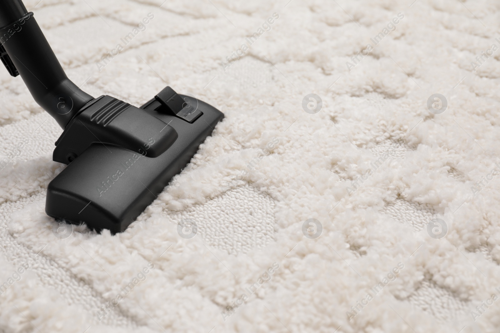 Photo of Hoovering carpet with modern vacuum cleaner, closeup. Space for text