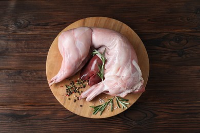 Photo of Whole raw rabbit, liver and spices on wooden table, top view