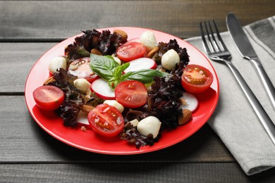 Delicious vegetable salad with mozzarella served on wooden table