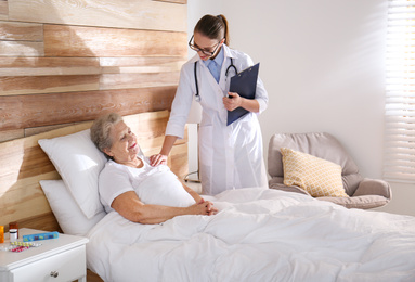 Photo of Doctor visiting senior patient in modern hospital