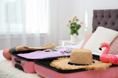 Modern suitcase with clothes packed for journey on bed indoors