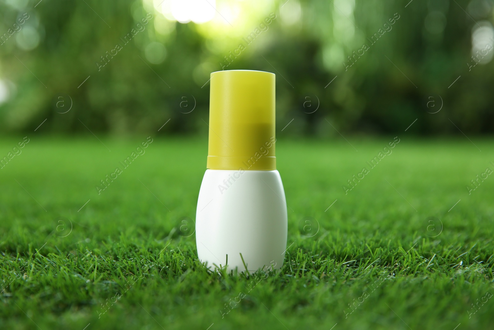 Photo of Bottle of insect repellent spray on green grass