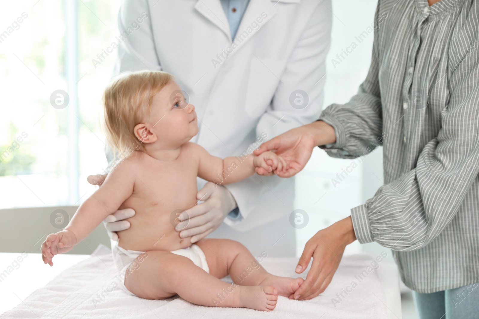 Photo of Mother with her baby visiting pediatrician in hospital. Health growth