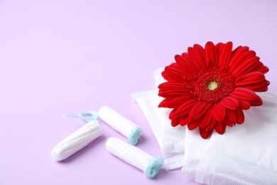 Different feminine hygiene products and flower on color background. Gynecological care