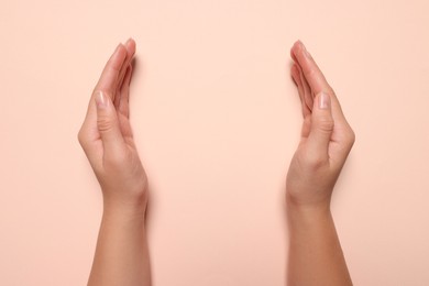 Photo of Woman holding on pale pink background, closeup of hands. Space for text