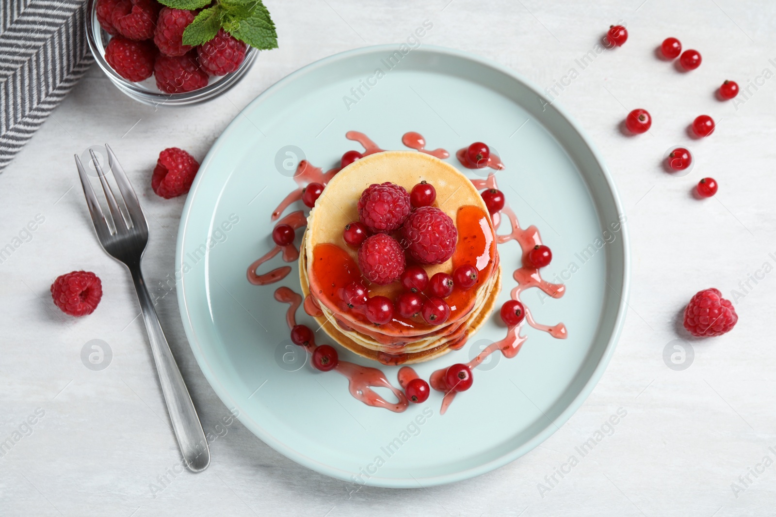 Photo of Tasty pancakes with berries served on light table