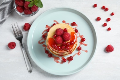 Tasty pancakes with berries served on light table