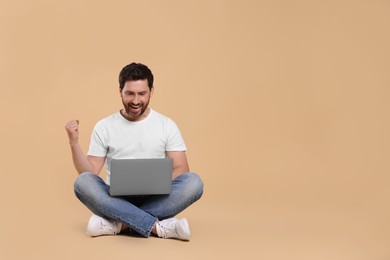 Photo of Emotional man with laptop on beige background. Space for text