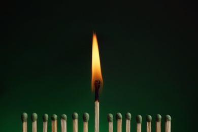 Burning match among others on color background. Difference and uniqueness concept