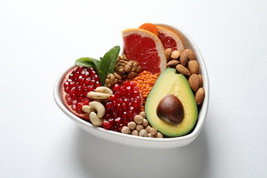 Photo of Bowl with products for heart-healthy diet on white background