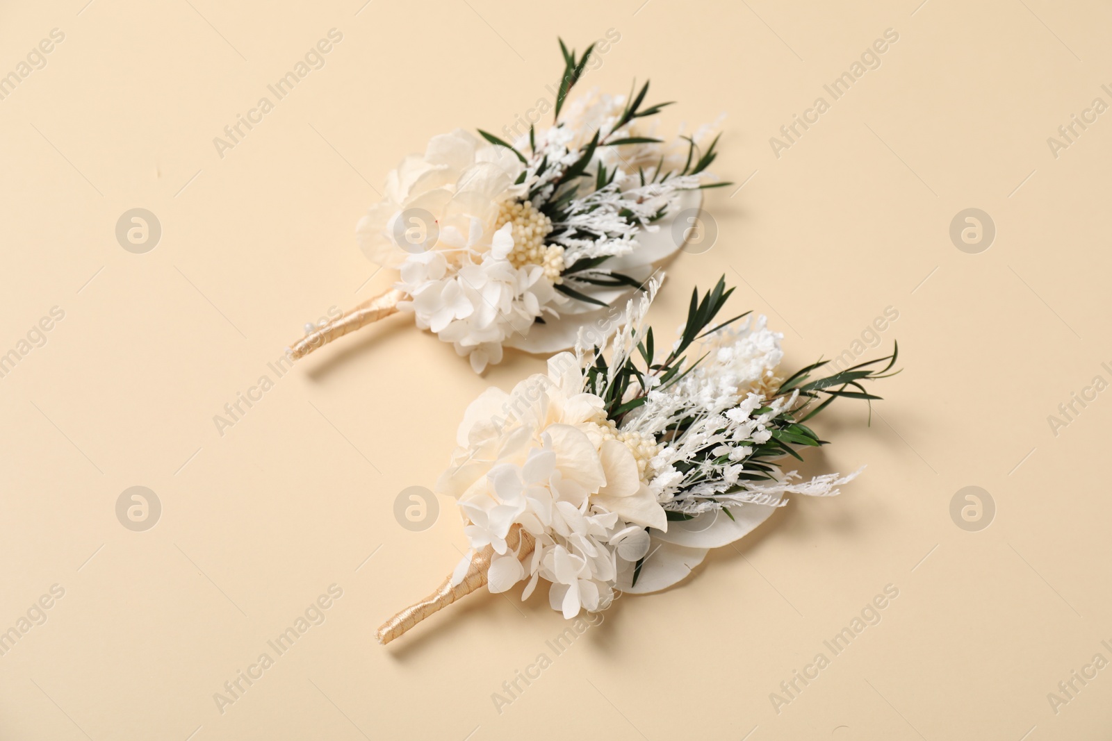 Photo of Stylish boutonniere on beige background, above view