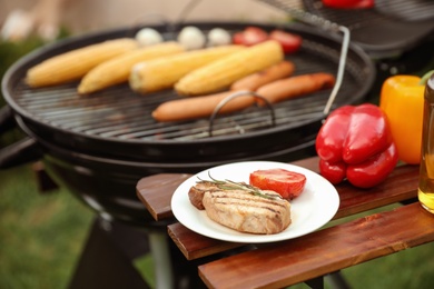 Photo of Barbecue grill with tasty fresh food outdoors, closeup