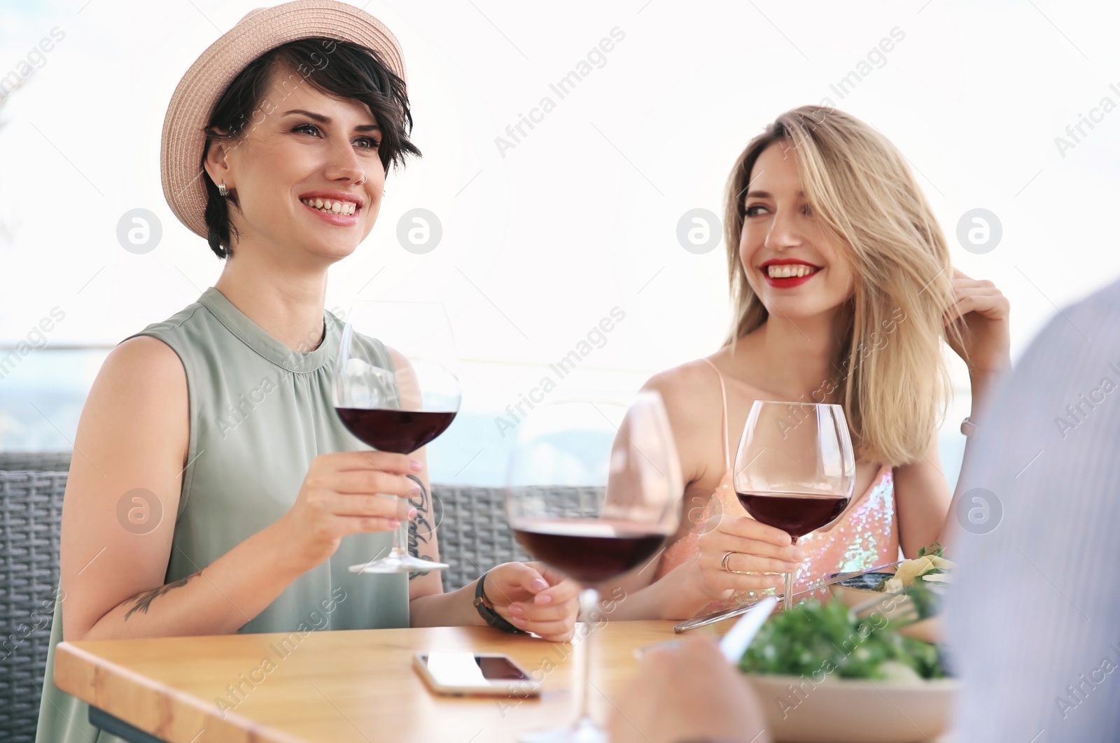 Photo of Group of friends with glasses of wine at table