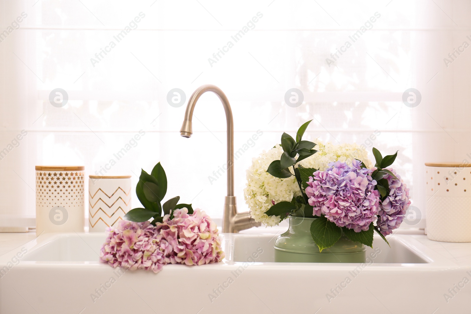 Photo of Bouquet with beautiful hydrangea flowers in sink