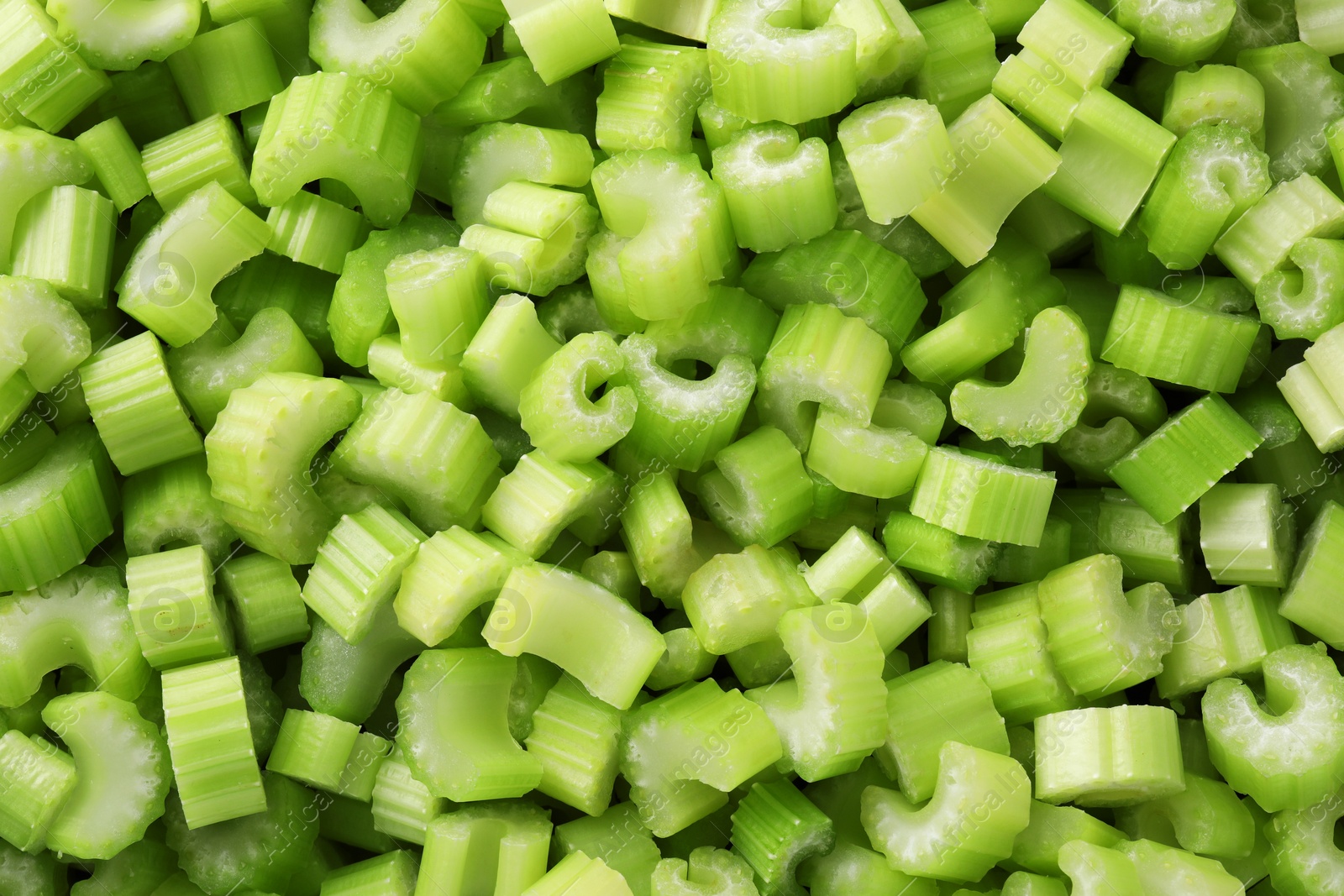 Photo of Fresh green cut celery as background, top view