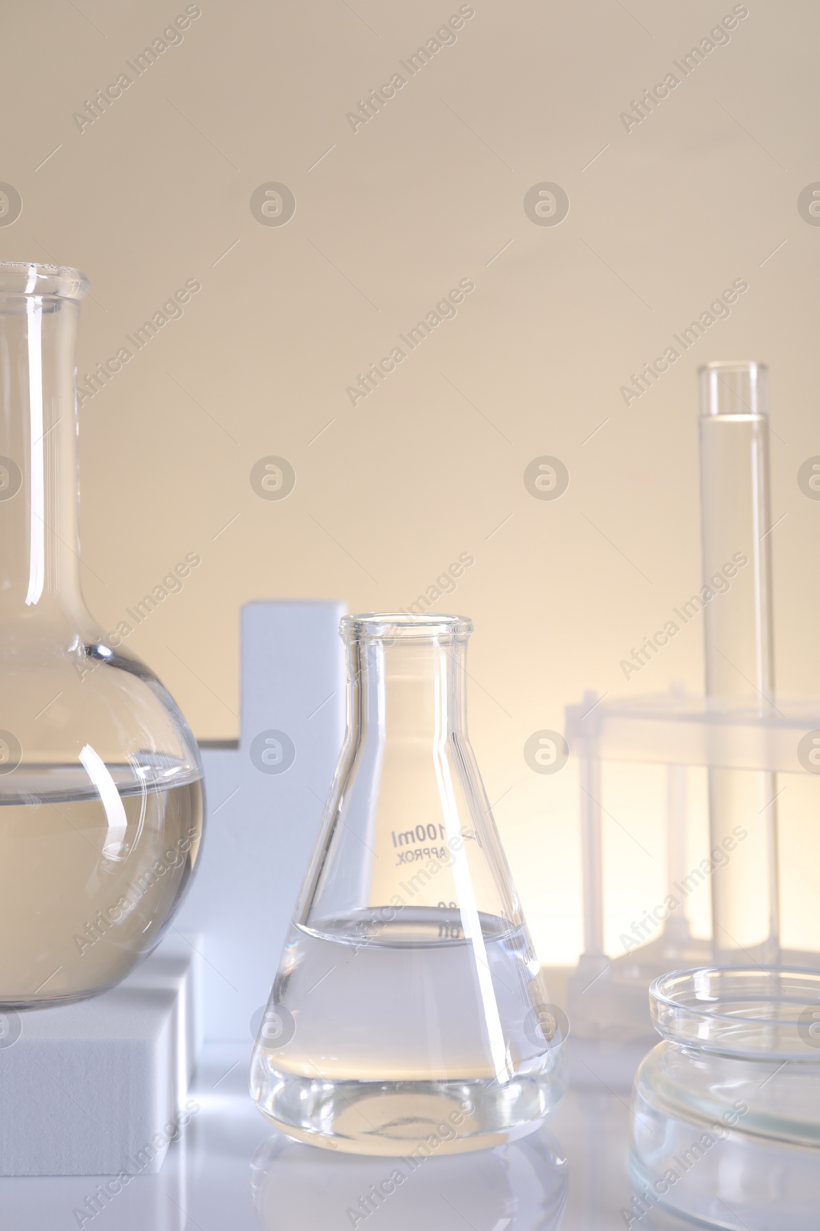 Photo of Laboratory analysis. Different glassware on table against beige background