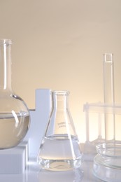 Laboratory analysis. Different glassware on table against beige background