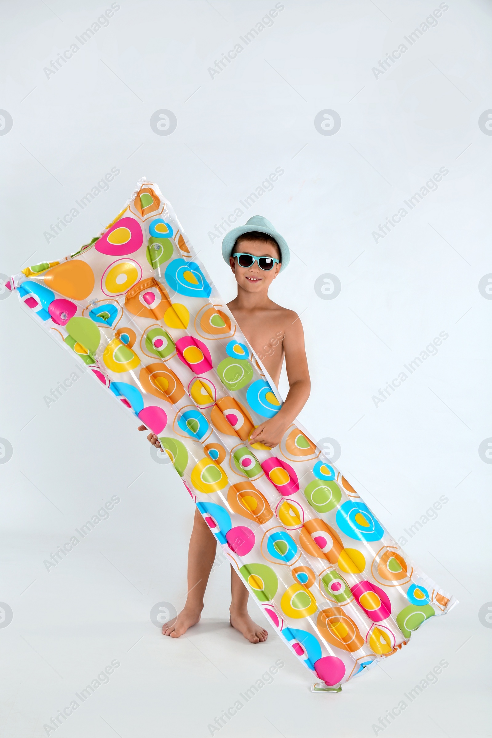 Photo of Cute little child with bright inflatable mattress on white background. Beach holiday