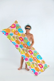 Cute little child with bright inflatable mattress on white background. Beach holiday