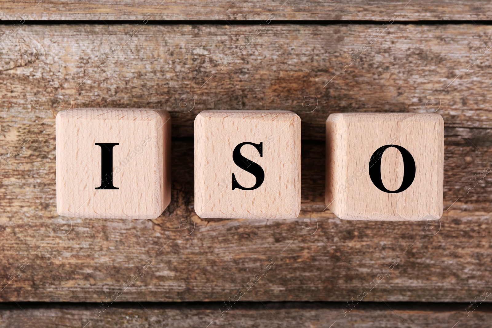 Photo of International Organization for Standardization. Cubes with abbreviation ISO on wooden table, top view