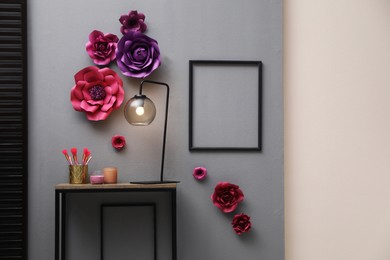 Lamp on table near wall with floral decor