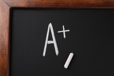 School grade. Letter A with plus symbol and chalk on blackboard, top view