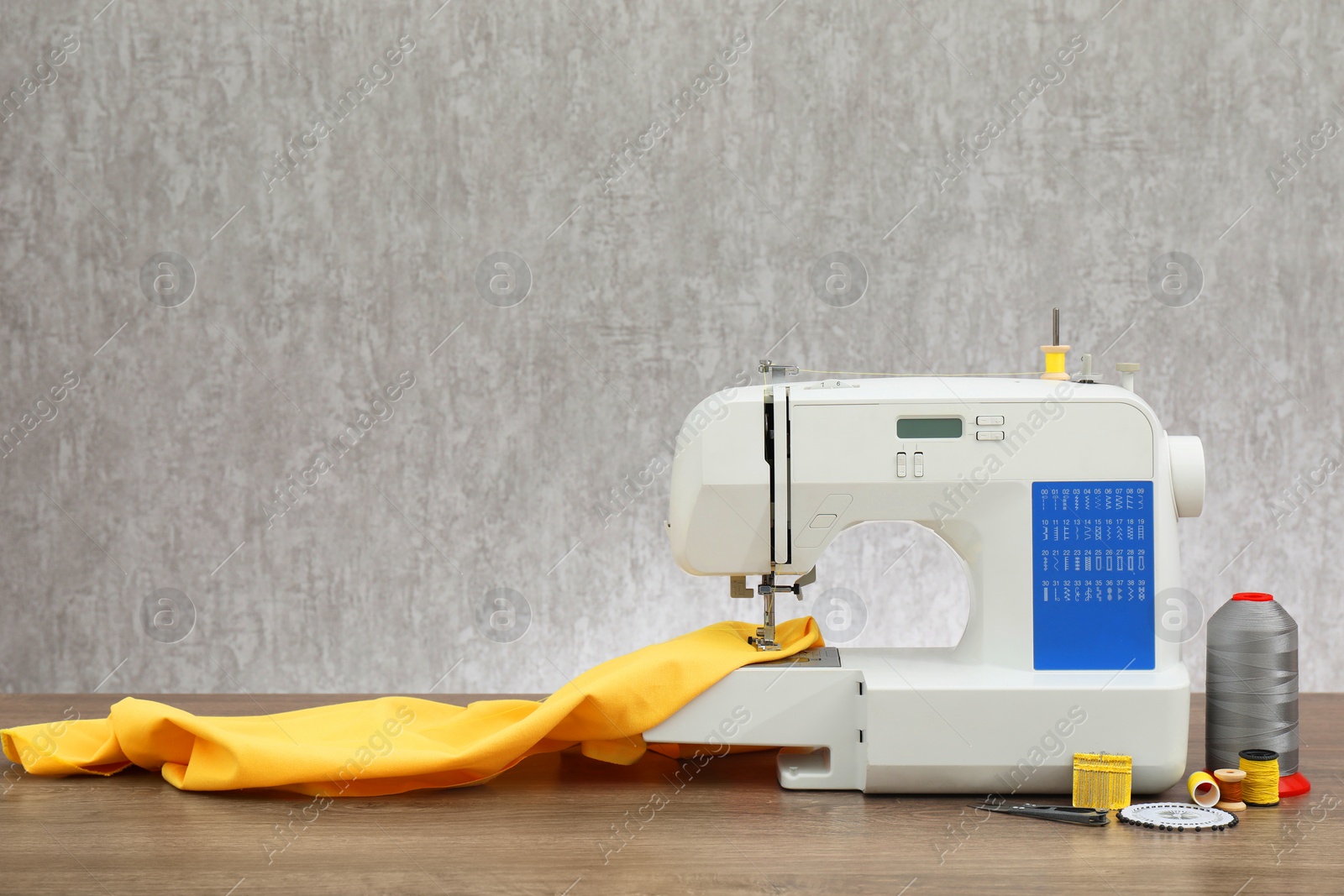 Photo of Sewing machine with fabric and craft accessories on wooden table