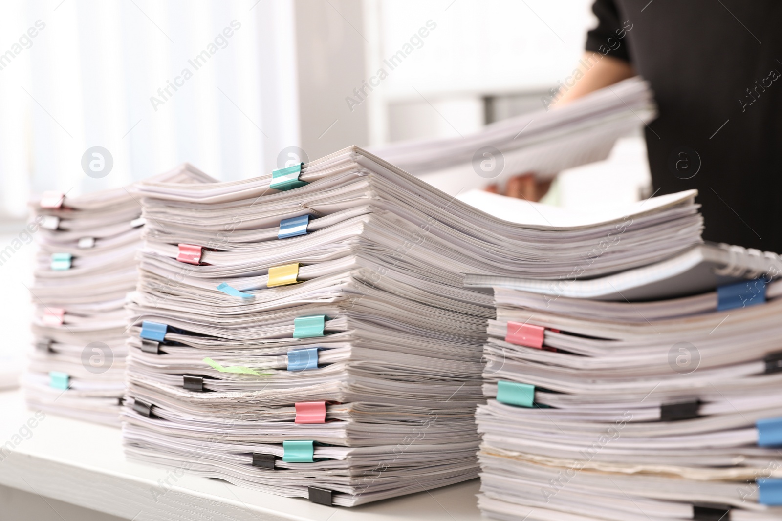 Photo of Stacks of documents with paper clips on office desk