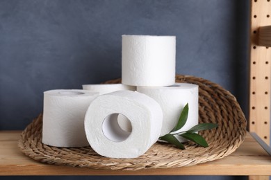 Photo of Toilet paper rolls and green leaves on wooden shelf