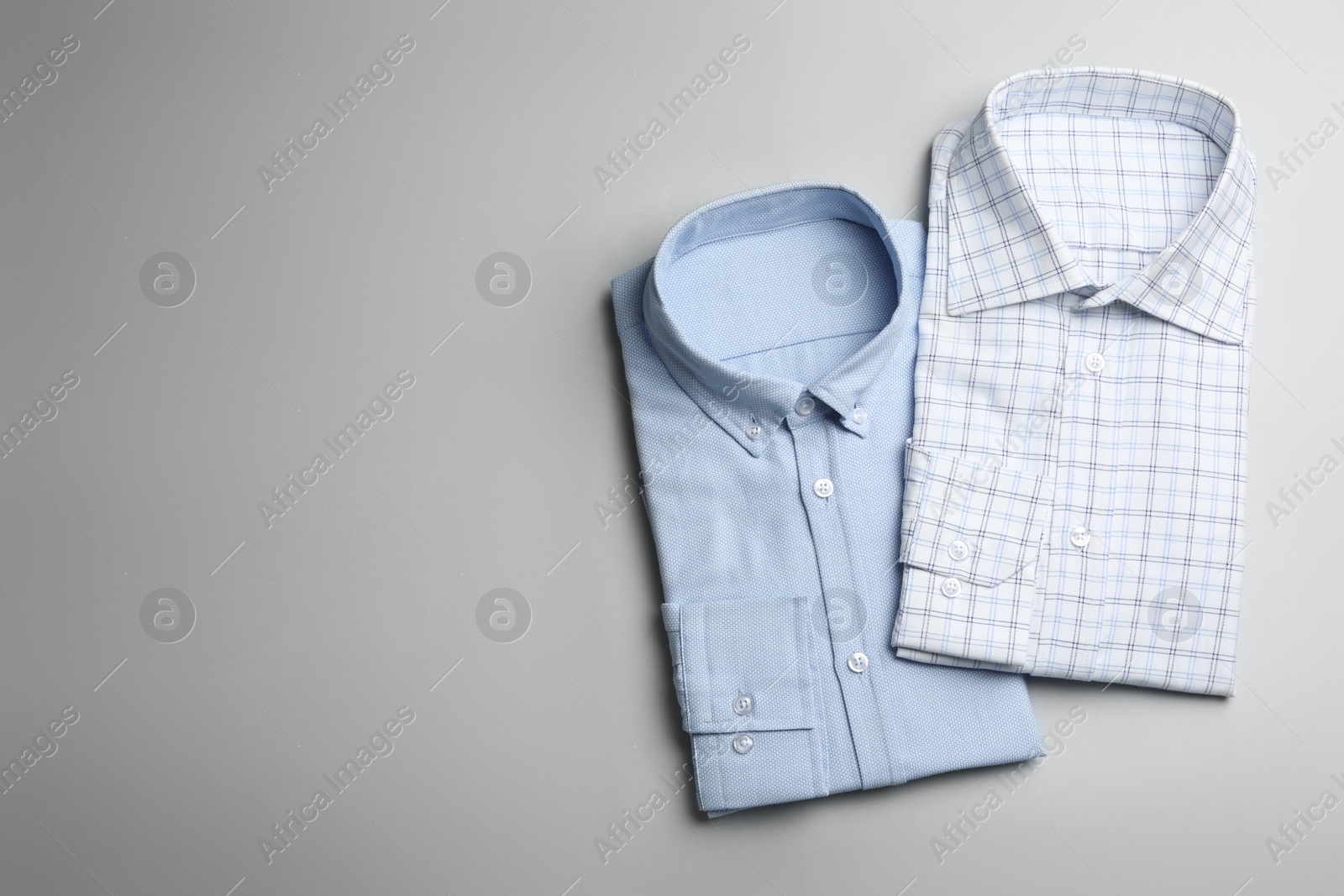 Photo of Stylish male shirts on light background, flat lay. Space for text