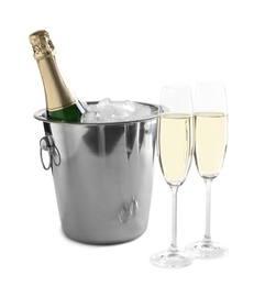 Glasses with champagne and bottle in bucket on white background