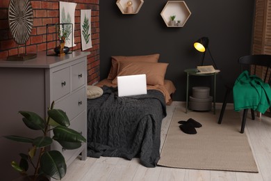 Photo of Stylish teenager's room with laptop, bed and chest of drawers