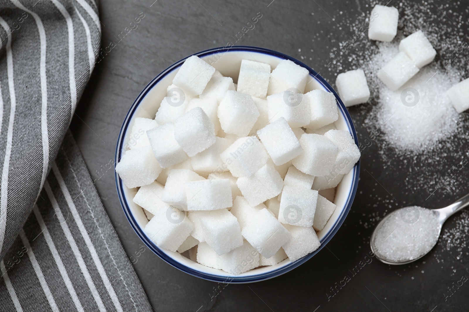 Photo of Flat lay composition with refined sugar cubes on black table, flat lay