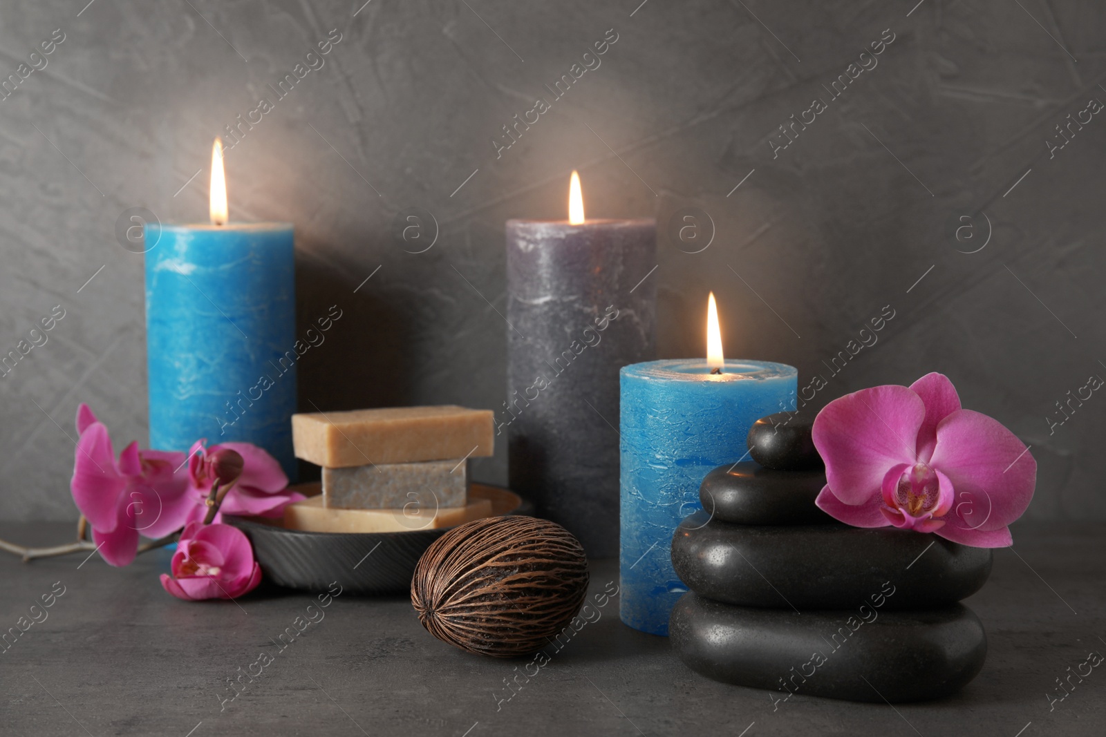 Photo of Beautiful composition with candles and spa stones on table