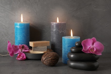 Beautiful composition with candles and spa stones on table