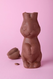 Photo of Broken chocolate Easter bunny on pink background