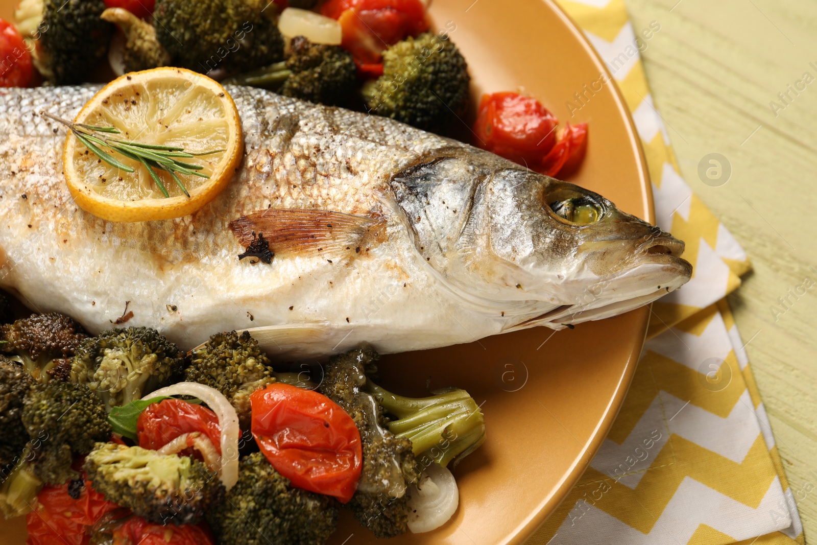 Photo of Delicious baked fish and vegetables on table, closeup