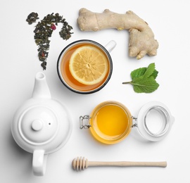 Composition with lemon tea, honey and ginger on white background, top view. Space for text