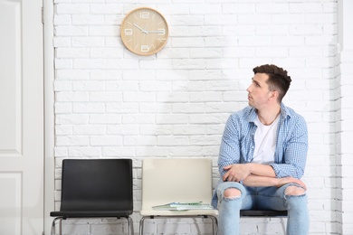 Young man waiting for job interview, indoors