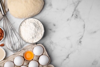 Flat lay composition with dough and flour on white marble table. Space for text