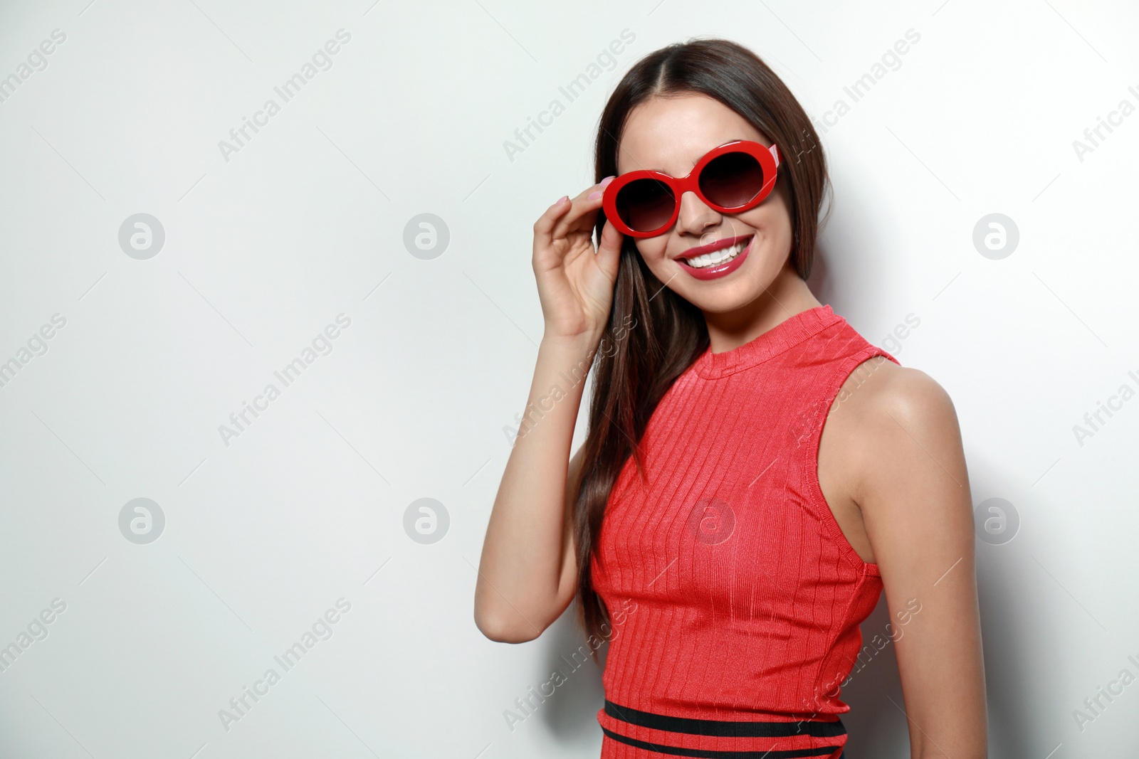 Photo of Beautiful woman in stylish sunglasses on light background, space for text