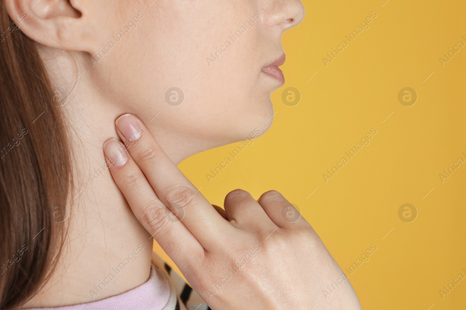 Photo of Young woman checking pulse against color background, closeup. Space for text