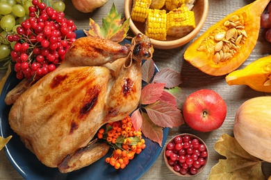 Photo of Flat lay composition with delicious turkey on wooden background. Happy Thanksgiving day