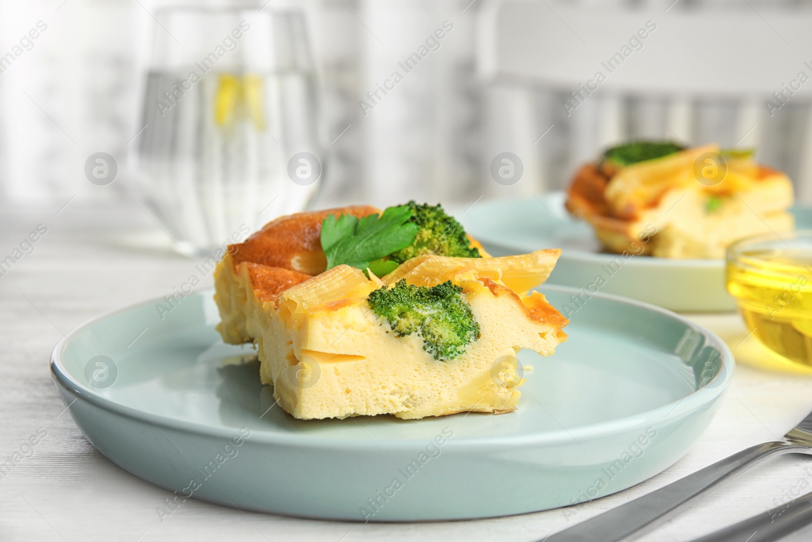 Photo of Tasty broccoli casserole served on white wooden table
