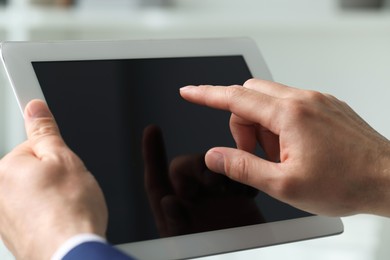 Photo of Closeup view of man using new tablet indoors