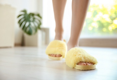 Photo of Young woman with sexy legs in soft slippers at home