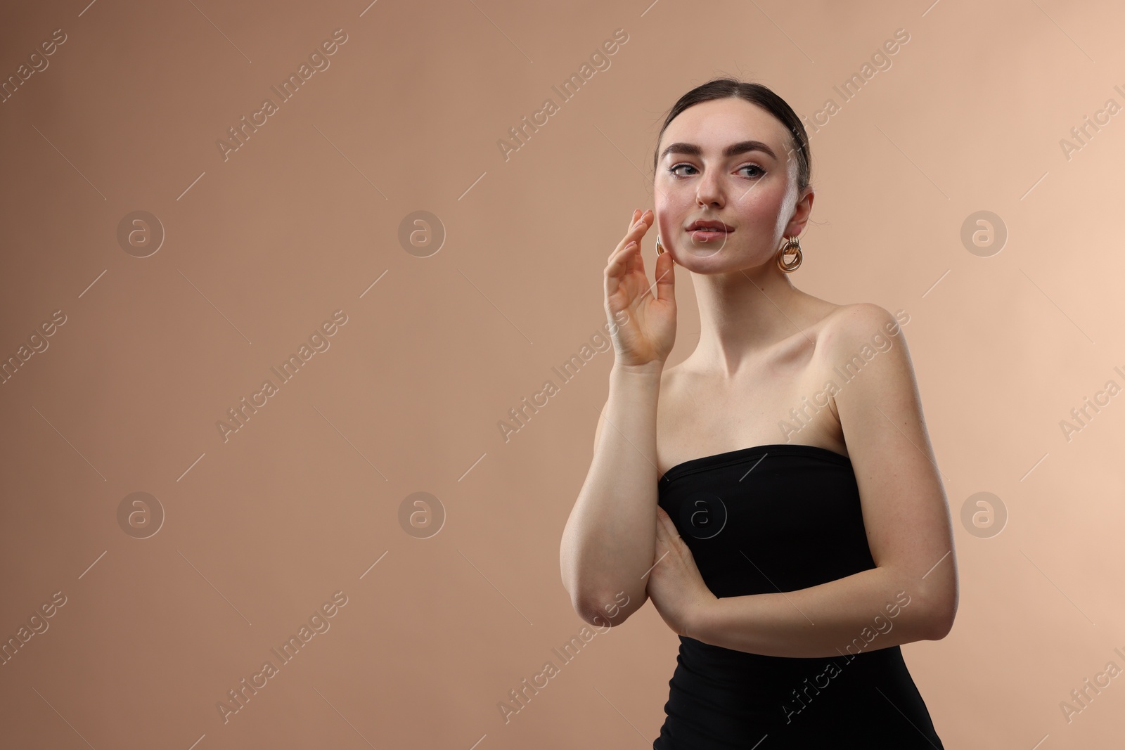 Photo of Portrait of beautiful young woman on beige background, space for text