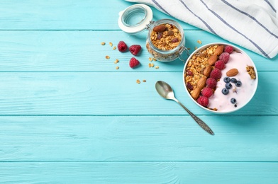 Tasty homemade granola served on blue wooden table, flat lay with space for text. Healthy breakfast